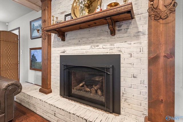 interior details with beamed ceiling and a brick fireplace