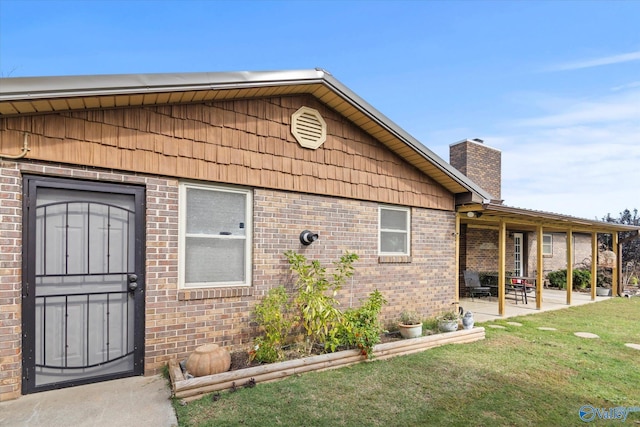 1707 Byron Rd, Scottsboro, AL 35769 - entrance to property with brick siding, a patio area, a yard, and a chimney