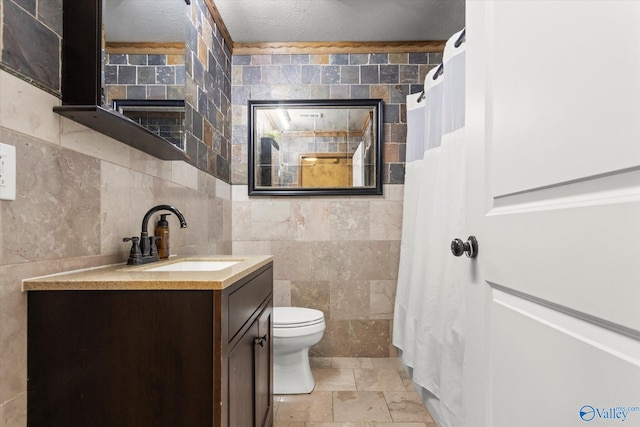 bathroom featuring a textured ceiling, toilet, tile walls, a shower with curtain, and vanity