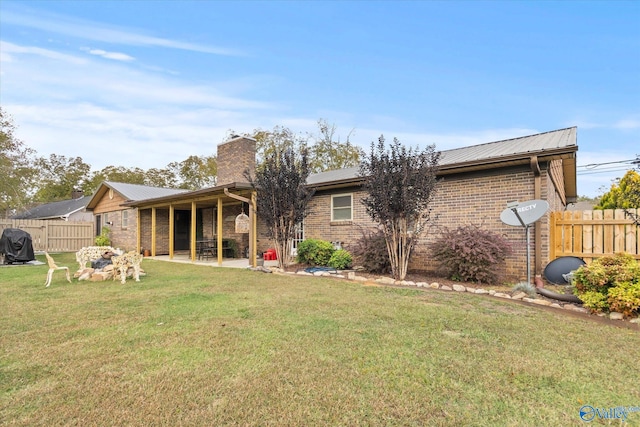 back of property with a yard and a patio area