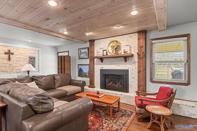 living room with wood ceiling, hardwood / wood-style flooring, beamed ceiling, and a brick fireplace