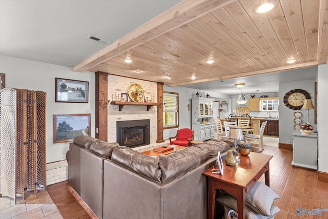 living room featuring hardwood / wood-style flooring, wooden ceiling, and a fireplace