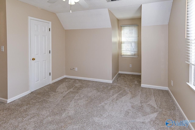 bonus room with a textured ceiling, ceiling fan, light colored carpet, and lofted ceiling