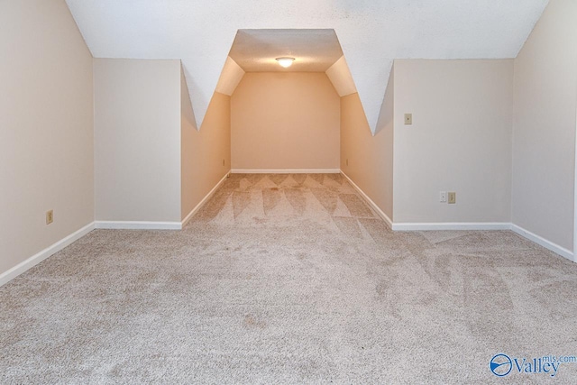 additional living space with light carpet and vaulted ceiling