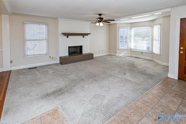 unfurnished living room with ceiling fan, a fireplace, a healthy amount of sunlight, and light carpet