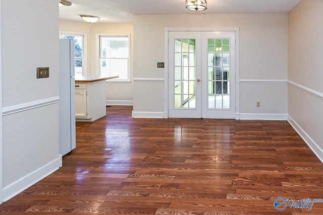 doorway to outside featuring dark hardwood / wood-style floors, a textured ceiling, and french doors