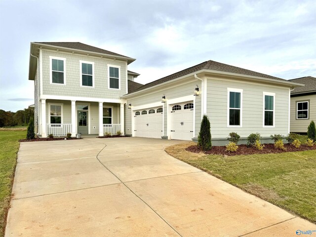 front facade featuring a front yard, a garage, and covered porch