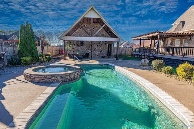 view of swimming pool with a pergola, a wooden deck, an in ground hot tub, and a patio area