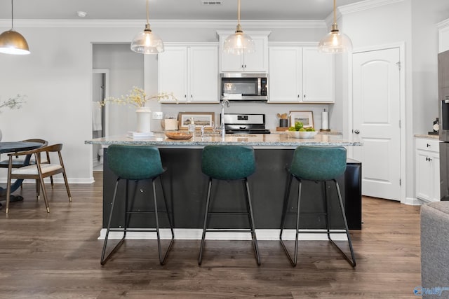 107 Sunlit Grove Dr, Harvest, AL 35749 - kitchen with appliances with stainless steel finishes, white cabinets, a kitchen bar, a center island with sink, and hanging light fixtures