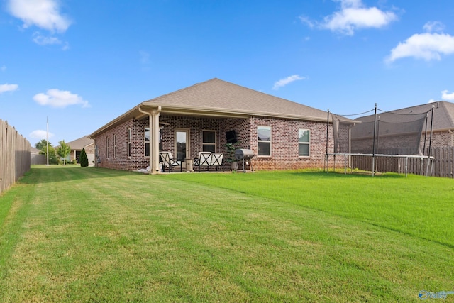 107 Sunlit Grove Dr, Harvest, AL 35749 - back of property featuring a trampoline, brick siding, and a patio area