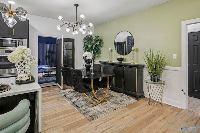 dining space featuring a chandelier and light wood-style flooring