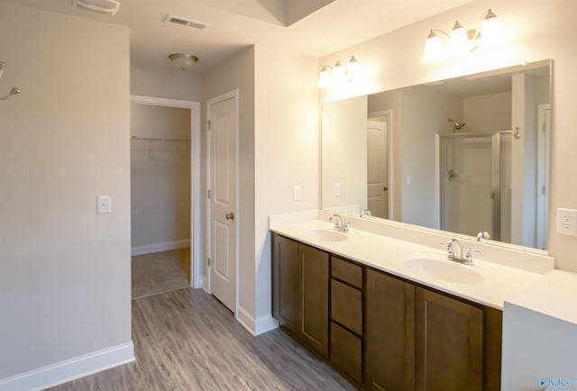 bathroom with vanity, a shower with shower door, and hardwood / wood-style floors