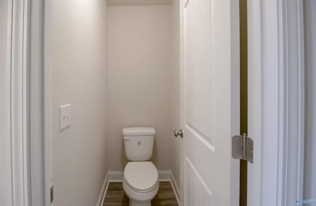 bathroom featuring wood-type flooring and toilet