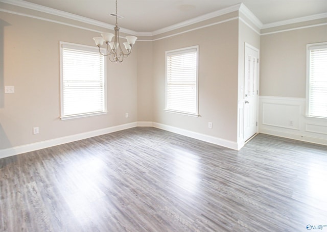 unfurnished room with a notable chandelier, crown molding, and dark hardwood / wood-style floors