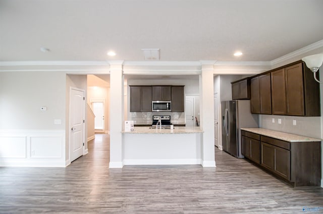 kitchen with backsplash, dark brown cabinets, stainless steel appliances, light stone countertops, and light hardwood / wood-style floors