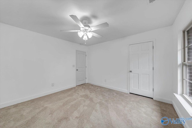 carpeted spare room featuring ceiling fan