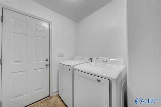 laundry room featuring separate washer and dryer and light tile patterned floors