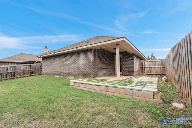 back of house featuring a lawn and a patio