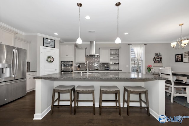 kitchen with tasteful backsplash, a breakfast bar, stainless steel appliances, wall chimney exhaust hood, and a sink