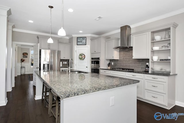 kitchen featuring visible vents, open shelves, stainless steel appliances, a sink, and wall chimney range hood