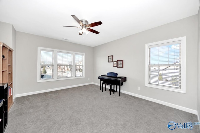 living area featuring carpet flooring, visible vents, a ceiling fan, and baseboards