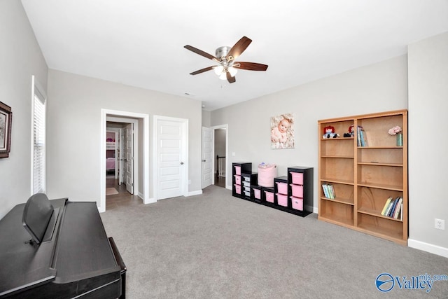 interior space with baseboards, ceiling fan, and carpet flooring