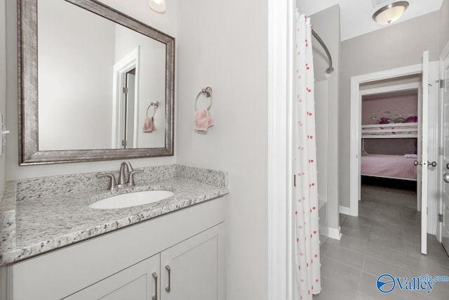 ensuite bathroom featuring tile patterned floors, curtained shower, connected bathroom, and vanity