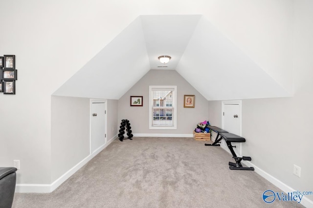 workout room with carpet flooring, visible vents, baseboards, and lofted ceiling