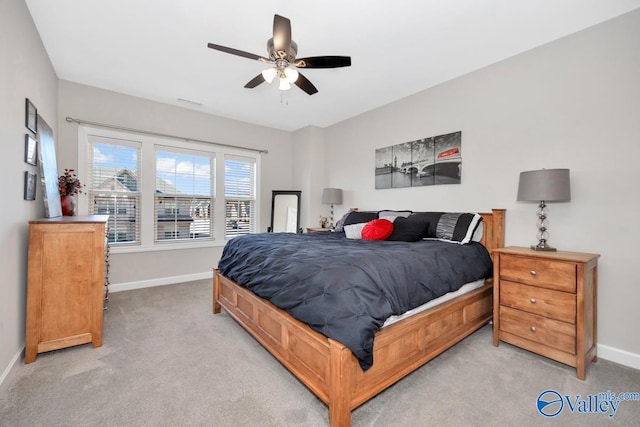 bedroom with light colored carpet, baseboards, and ceiling fan