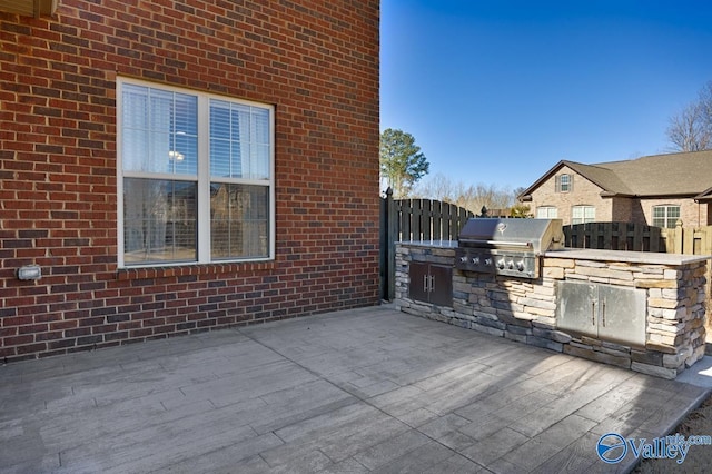 view of patio featuring grilling area, exterior kitchen, and fence