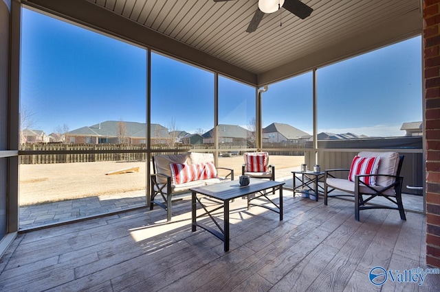 sunroom featuring a ceiling fan and a residential view