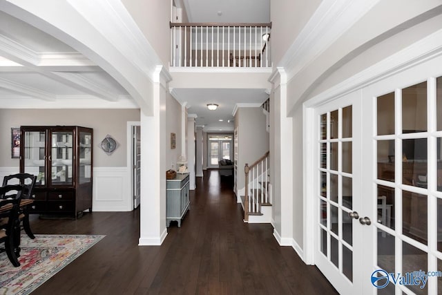 foyer entrance featuring dark wood finished floors, french doors, stairs, and ornamental molding