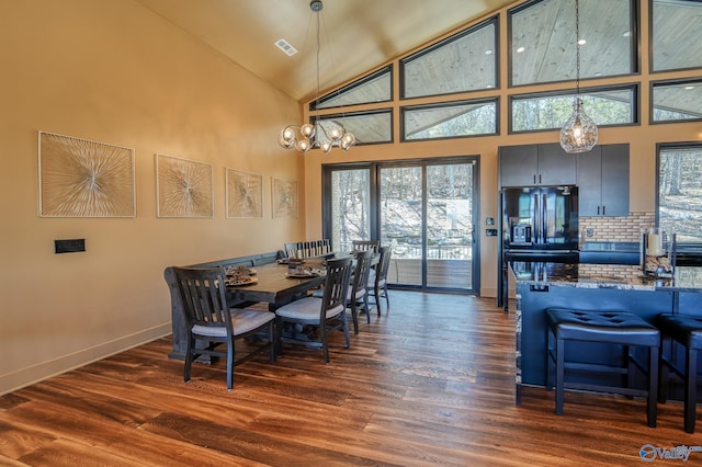 dining space with high vaulted ceiling, dark wood finished floors, visible vents, and baseboards