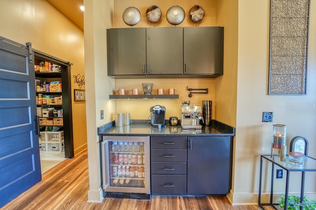 bar featuring a dry bar, a barn door, beverage cooler, and wood finished floors