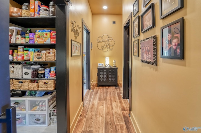 corridor featuring baseboards and wood finished floors