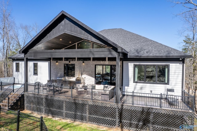 back of property featuring roof with shingles, fence, a wooden deck, and stairs