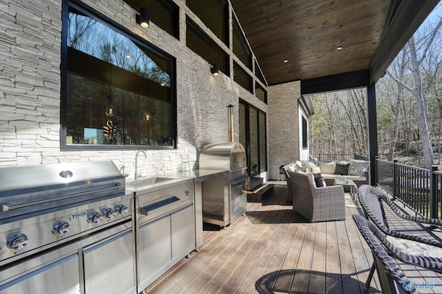 deck featuring exterior kitchen, grilling area, an outdoor hangout area, and a sink