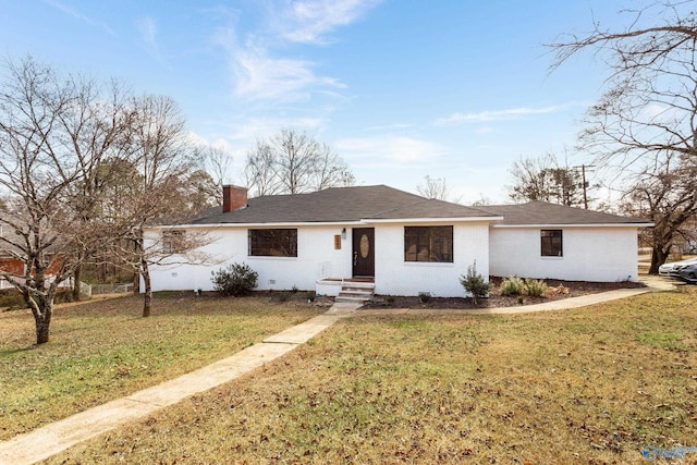 ranch-style home with a front yard and a chimney