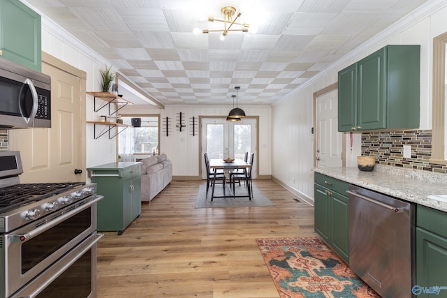 kitchen with decorative backsplash, light wood-style flooring, appliances with stainless steel finishes, crown molding, and green cabinets