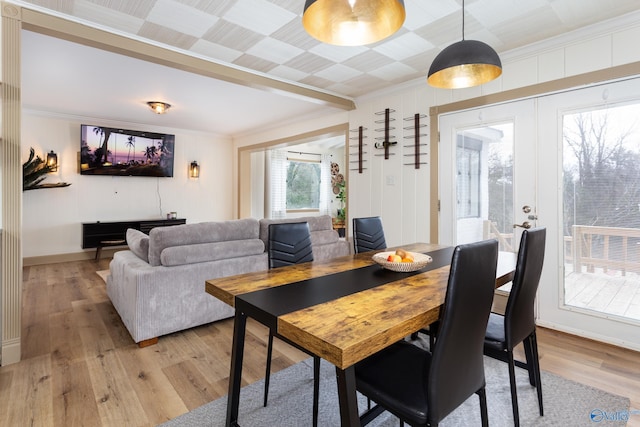 dining area featuring light wood-style floors, ornamental molding, and french doors