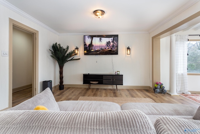 living room featuring baseboards, light wood-type flooring, and crown molding