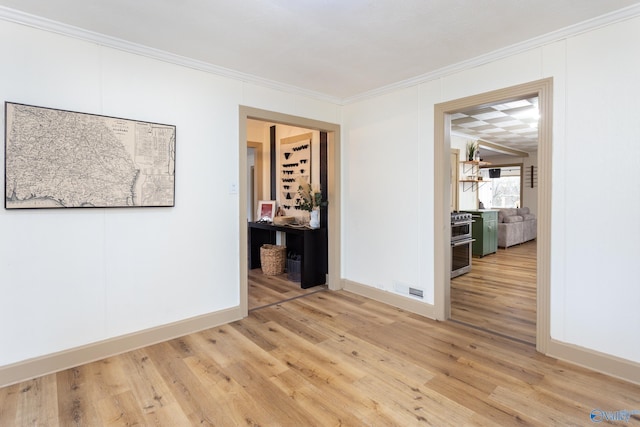 spare room featuring baseboards, ornamental molding, and wood finished floors