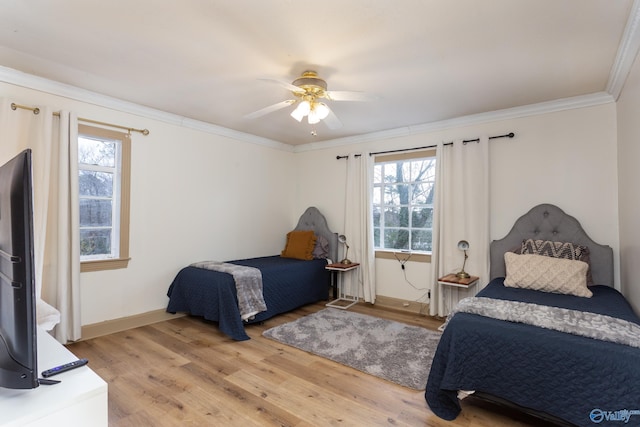 bedroom featuring ornamental molding, wood finished floors, a ceiling fan, and baseboards