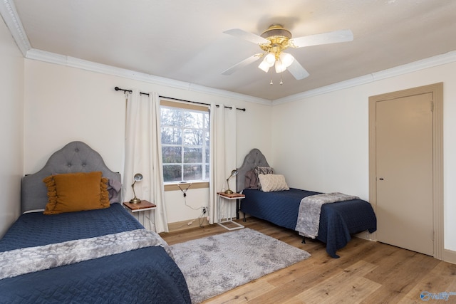 bedroom featuring ceiling fan, wood finished floors, and crown molding