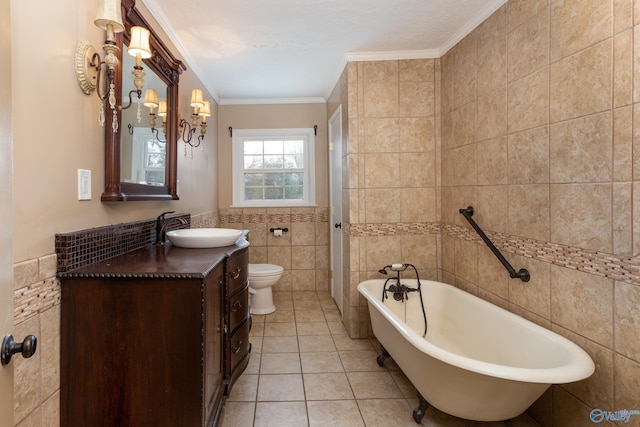 full bath featuring a freestanding tub, toilet, tile walls, tile patterned floors, and crown molding