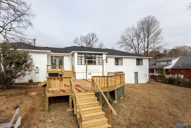 back of house with a deck, brick siding, and stairway