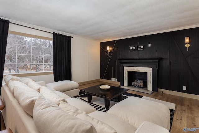 living room with a fireplace, baseboards, and wood finished floors