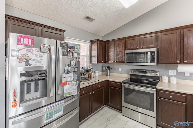 kitchen with appliances with stainless steel finishes, dark brown cabinets, lofted ceiling, and a textured ceiling