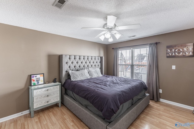 bedroom featuring a textured ceiling, light hardwood / wood-style floors, and ceiling fan