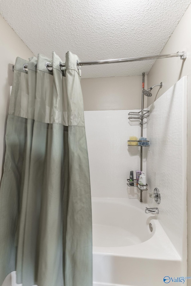 bathroom featuring shower / bath combination with curtain and a textured ceiling